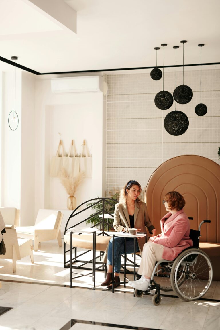 A business meeting between two women, one in a wheelchair, in a stylish modern room.
