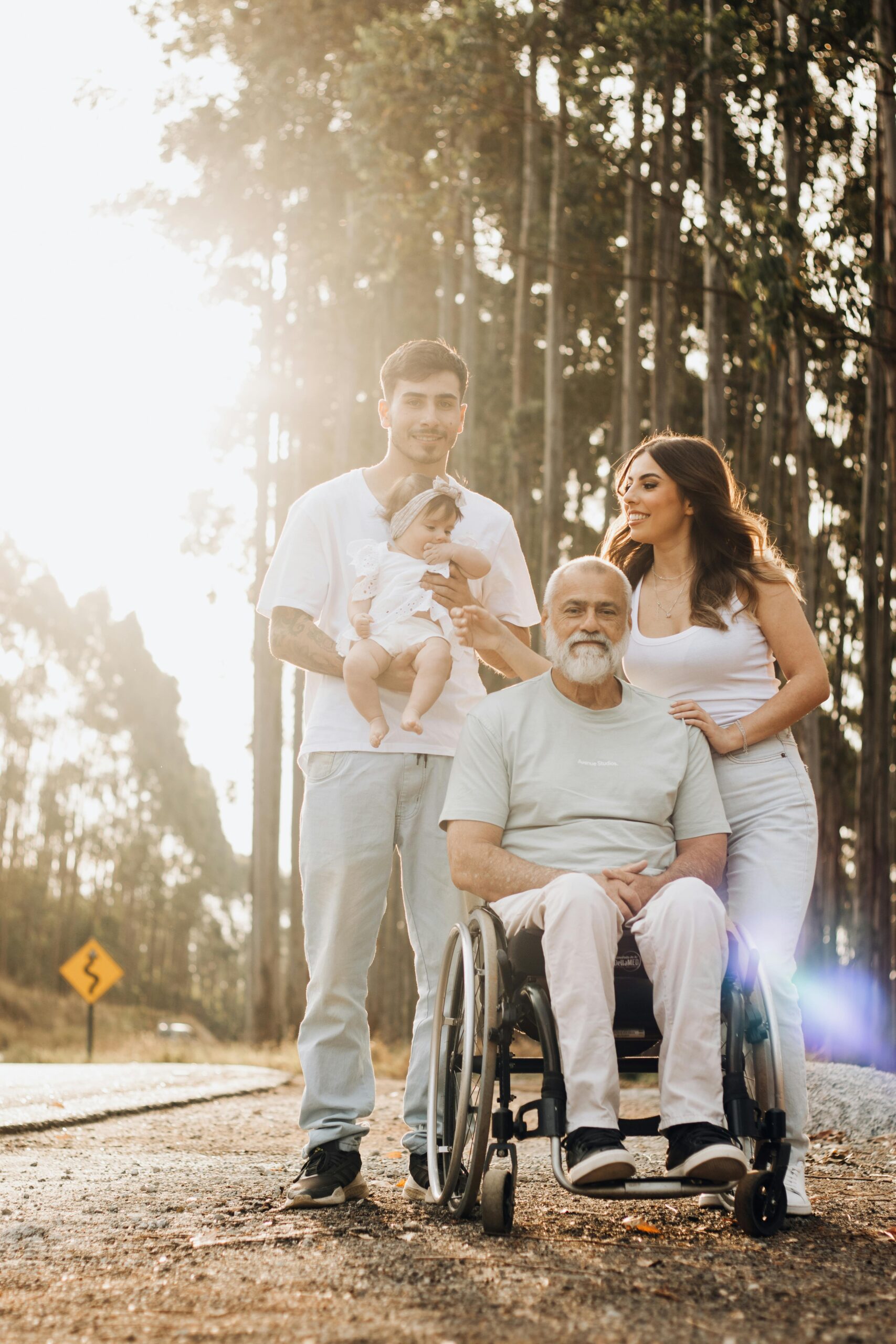 A heartwarming family scene in a sunlit park, featuring a grandfather in a wheelchair with his family.